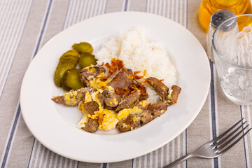 Delicious fried omelette with pieces of rabbit liver, boiled white rice and fragrant pickled cucumber slices