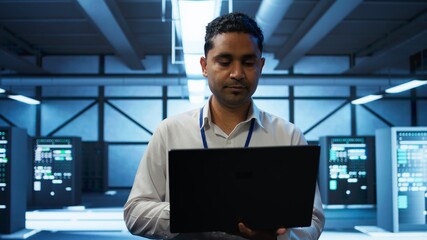 System administrator in data center using notebook to design, implement and manage gear, ensuring...
