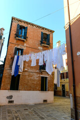 Typical city corner with ancient colorful buildings Drying clothes on a clothes-line in outdoor at sunny summer day. Venice, Italy