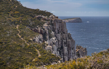 Breathtaking view of Cape Hauy Tasmania featuring rugged cliffs lush greenery and the vast ocean....
