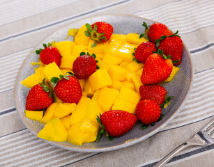 Sweet juicy mango slices served with delicious strawberries
