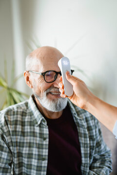 The doctor measures the patient's temperature