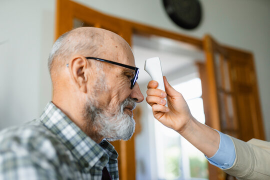 The doctor measures the patient's temperature