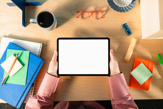 A woman uses a tablet with white screen