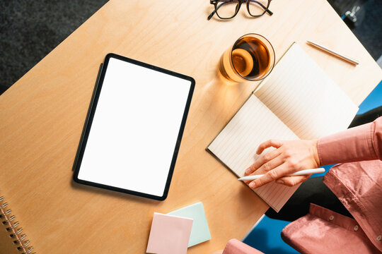 A woman uses a tablet with white screen
