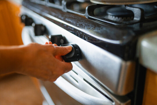 The woman turns on the stove