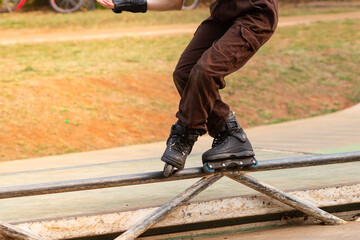 Girl practicing the soul grind maneuver on the railing on roller skates