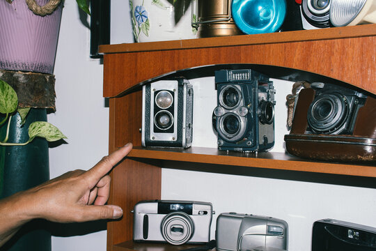 Hand pointing at antique cameras,