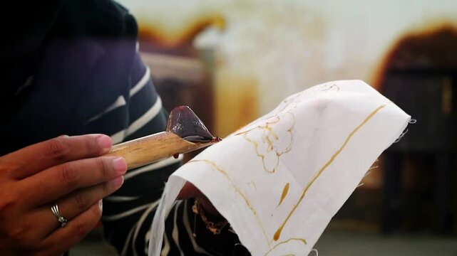 Close up woman holding canting painting pattern batik motif parang hand drawn batik