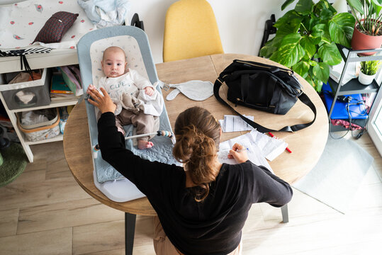 Mother managing work and baby at home