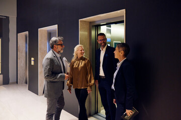 Colleagues talk near the elevator