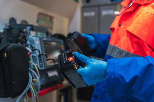 Paramedic preparing defibrillator paddles 
