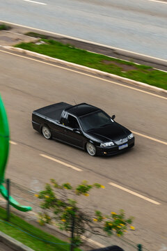 Black customized Volkswagen Saveiro on a highway - Panning shot of a lowered pickup truck
