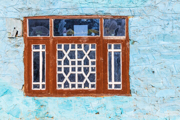 Kangan, Jammu and Kashmir, India. A wooden framed window in a blue house.