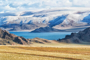 Asia, Mongolia, Bayan-Olgii Province, Altai Mountains. Scenic view of the rugged mountains with grasslands and Lake Tolbo in the foreground.