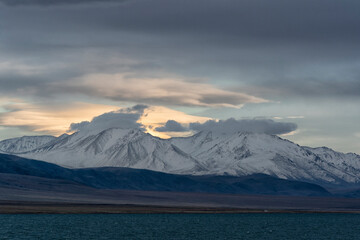 Asia, Mongolia, Bayan-Olgii Province, Altai Mountains, Lake Tolbo. Scenic view of the rugged, snow covered mountains rising above Lake Tolbo.