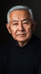Obraz premium Portrait of an elderly Asian man wearing black turtleneck sweater against dark background, with dignified expression and silver hair, showcasing wisdom and life experience in dramatic lighting.