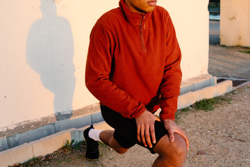 Unidentified athlete deeply focused on a leg stretch in the open air