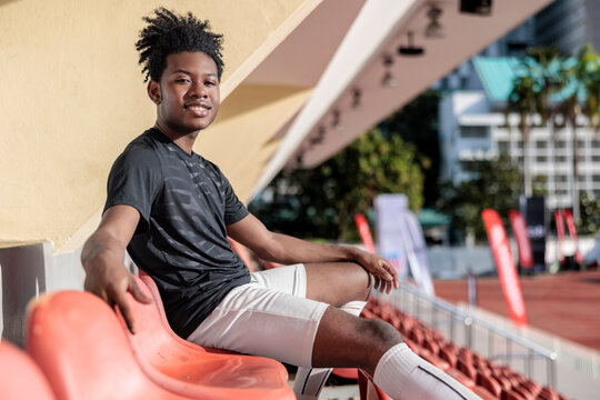 Smiling male sitting on seat in stadium