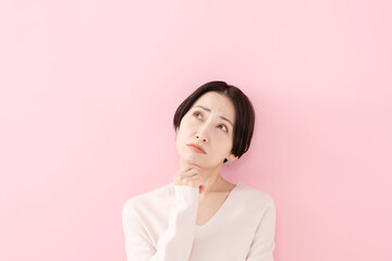 悩む・考える・困る女性・ピンクバック