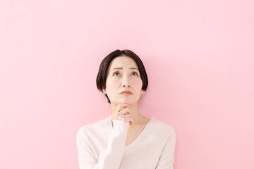 悩む・考える・困る女性・ピンクバック