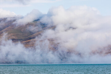 Armenia, Gegharkunik Province. Clouds and mist over Lake Sevan.