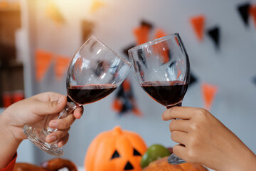 friendship, holiday and people concept - group of happy smiling friends in halloween costumes of vampire, devil, witch and cheetah at home party