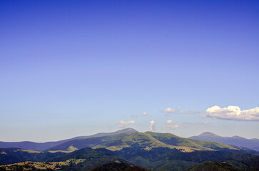 Picturesque landscape featuring rolling green hills and mountains Petros and Hoverla beneath a...