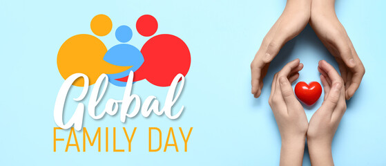 Hands of woman and child with red heart on blue background