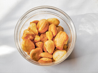 Dried garlic chips in transparent jar isolated white background