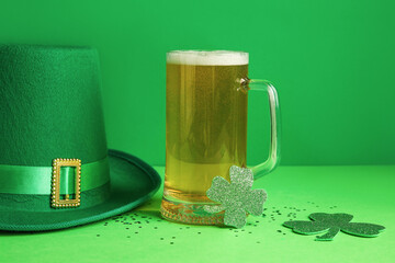 Glass of beer with leprechaun hat and clover on green background. St. Patrick's Day celebration