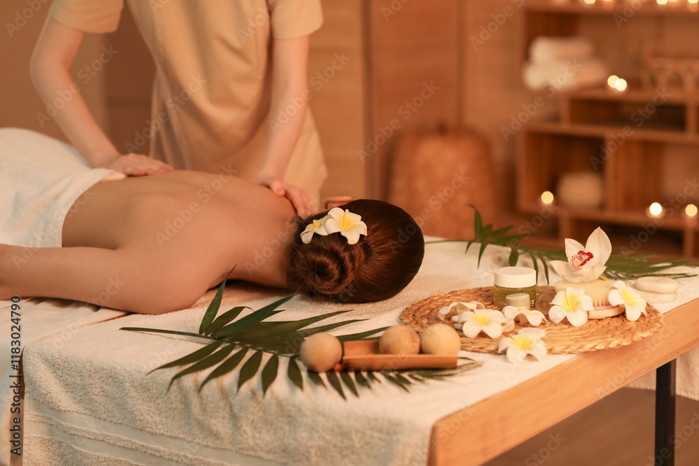 Wall mural Young woman getting back massage in spa salon