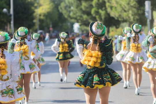 Hispanic dancers wearing traditional clothes marching in parade celebrating national holiday. 