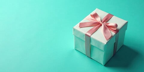 A delicately tied pale pink ribbon adorns a pristine white gift box on a vibrant teal background