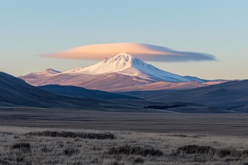 Fototapeta premium Majestic snow-capped mountain landscape featuring a captivating lenticular cloud formation at sunrise, showcasing the beauty of nature and tranquil scenery.