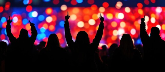 Energetic silhouettes of cheering clapping and dancing crowd at a vibrant colorful music festival concert  The blurred bright background highlights the energy and enthusiasm of the audience
