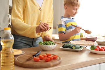 Parents with their little son cooking Fajita in kitchen, closeup