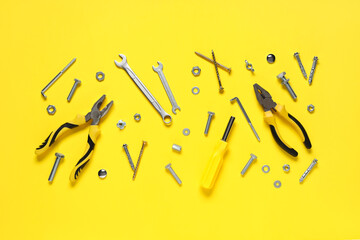 Tap bolts, screws and tools on yellow background