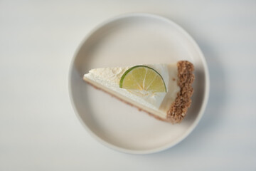 Vanilla Cheesecake with lemon filling and lemon slices on top in white dish