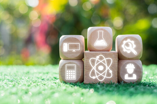 Creative representation of STEM education with icons for science, technology, engineering, and math on wooden blocks.