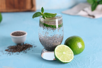 Glass of water with chia seeds, limes and mint on blue grunge background