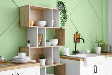 Interior of stylish kitchen with clean dishes on shelves and counters