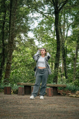 Happy Woman in Casual Outfit Enjoying a Peaceful Forest Setting Outdoors