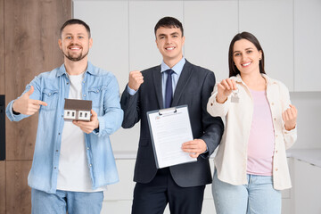 Real estate agent with house rental agreement and pregnant couple in kitchen