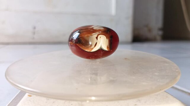 A beautiful blood red stone souvenir with a round shape rotated in a display case