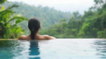 Fototapeta premium Soaking in the infinity pool while experiencing the serene beauty of the rainforest and gentle rain on a quiet day