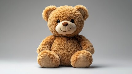 Obraz premium Soft teddy bear sitting against a neutral background.