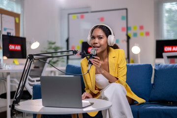 A woman in a yellow jacket is recording a podcast