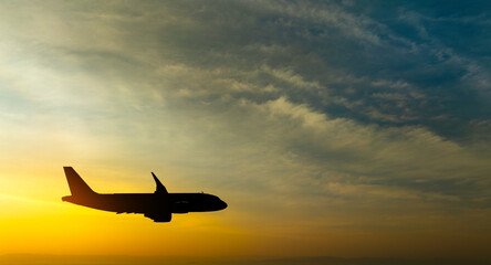 Passenger plane flying in the sky at sunrise. Airplane flying over mountains. Travel concept by plane and international travel.