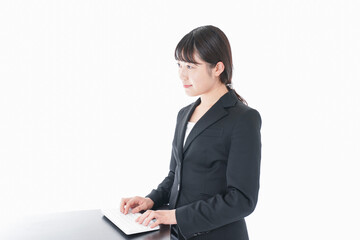 立ってデスクワークをする若いビジネスウーマン